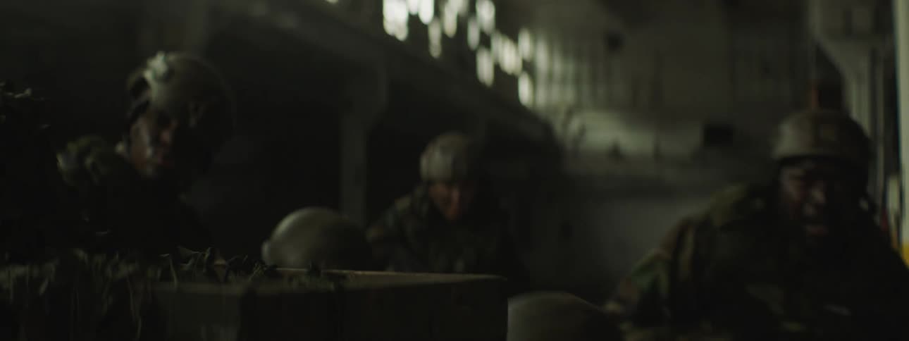 Four soldiers find cover in the dark warehouse