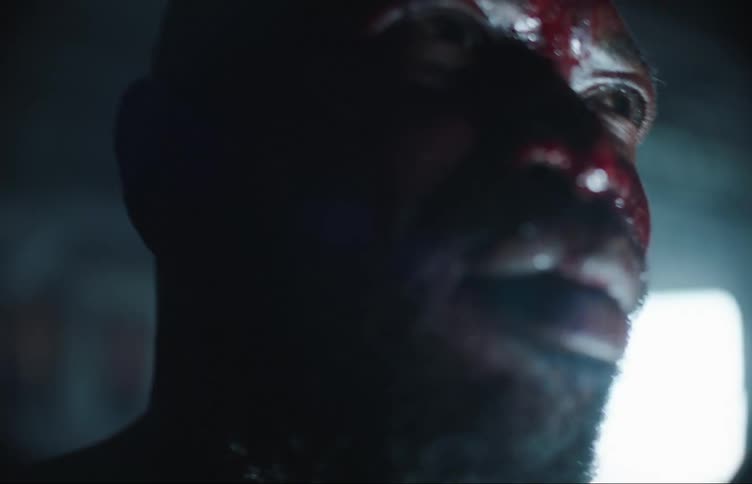 White lights flash on a fighters blood and sweat covered face