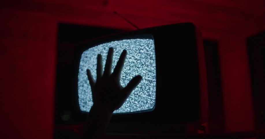 A person is touching a television screen indoors
