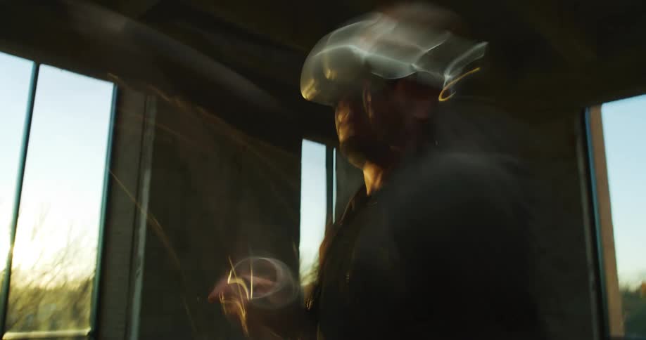 Man standing inside a room at sunset playing a virtual reality vr game