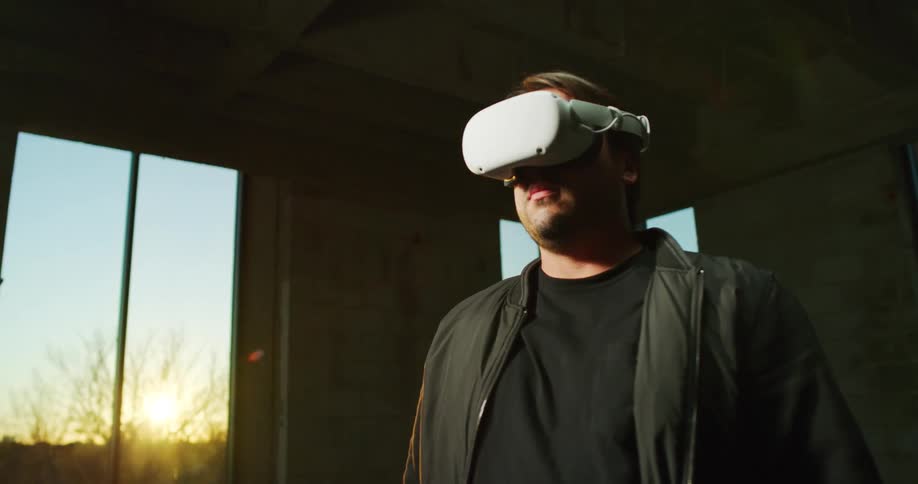 A man putting on a virtual reality headset in a room
