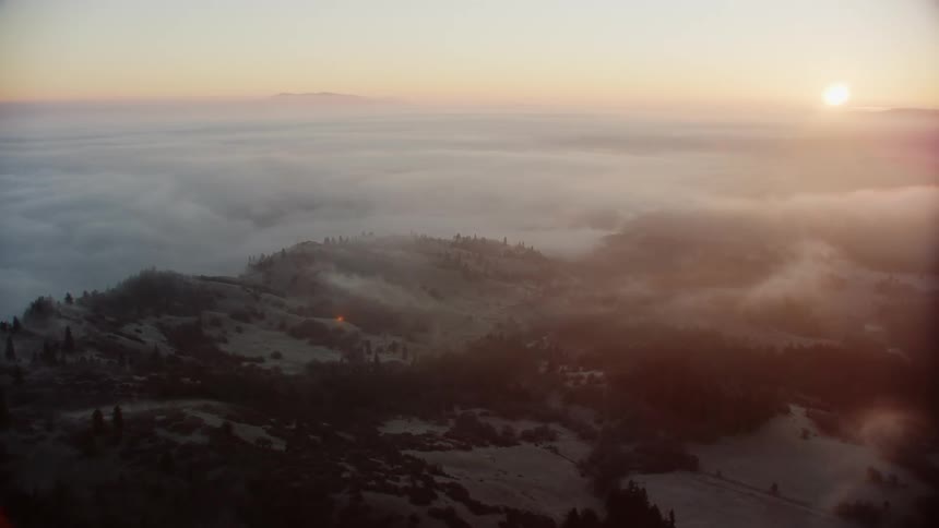 Aerial view of a cloudy landscape is displayed at dusk