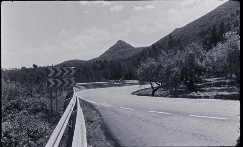 Highway with guardrail curves around mountains