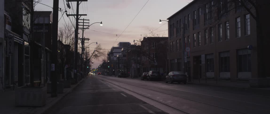 An empty street has cars in the distance
