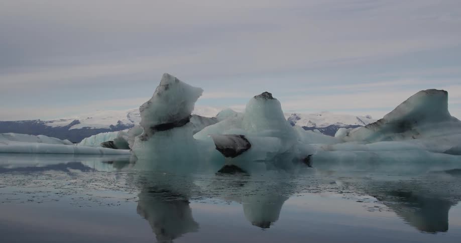 Water flows past large rock and ice formations