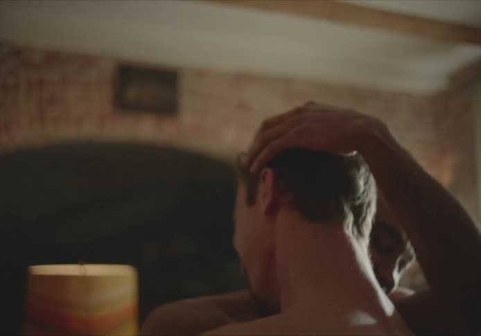Two men slow dance in each others arms smiling and laughing