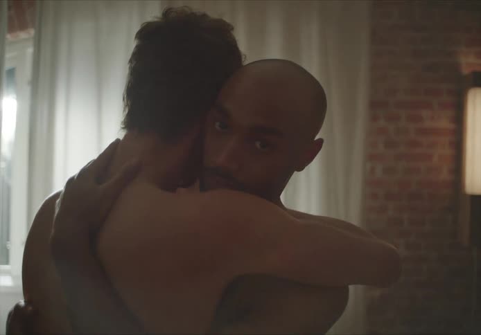 Young shirtless couple hugging each other on the living room at home