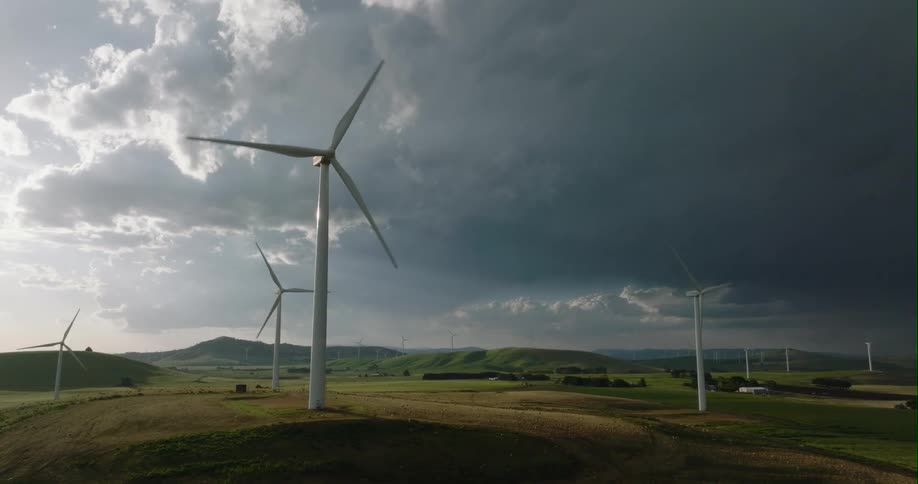 Dark storm clouds over a wind turbine farm