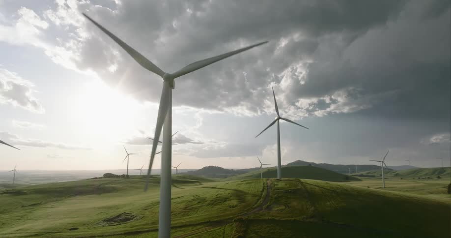 Dark storm clouds over wind turbines on rolling hills