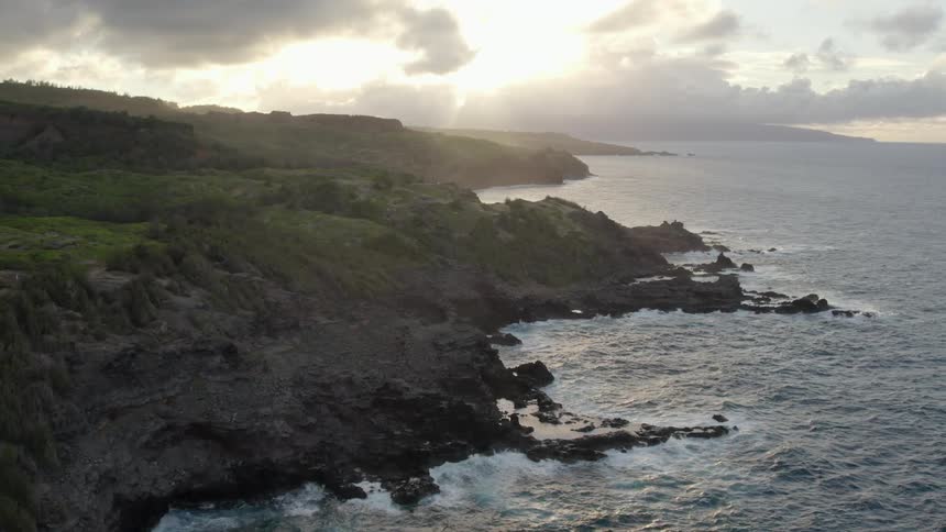 The waves crash against the shore of the island