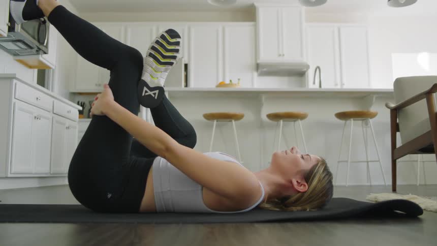 Fit woman stretching on yoga mat