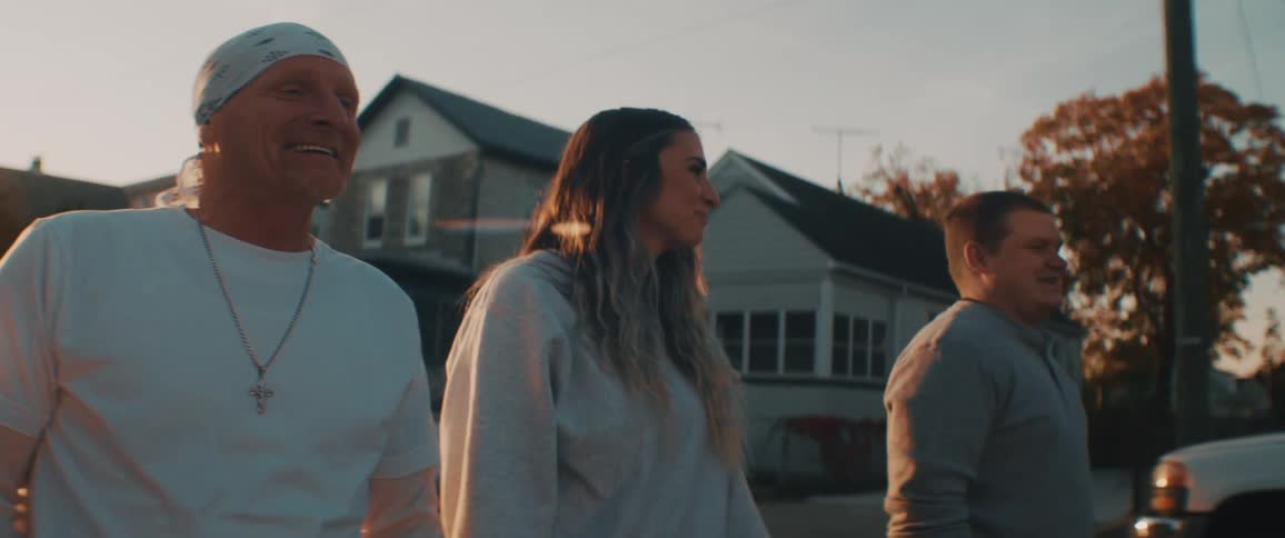 Group of friends talking and smiling while walking on the neighborhood street at sunset