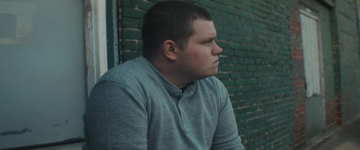 Man sits on stoop near door thinking