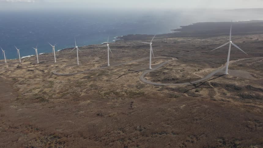 Aerial view of wind turbines on the coast next to the ocean