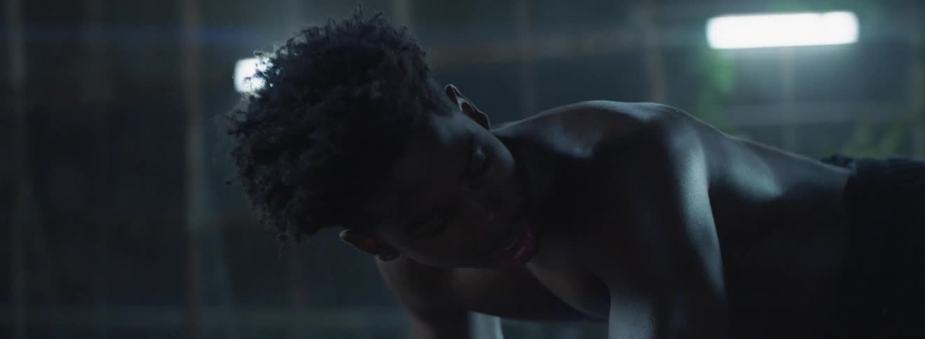 A man is crouched in a dark area
