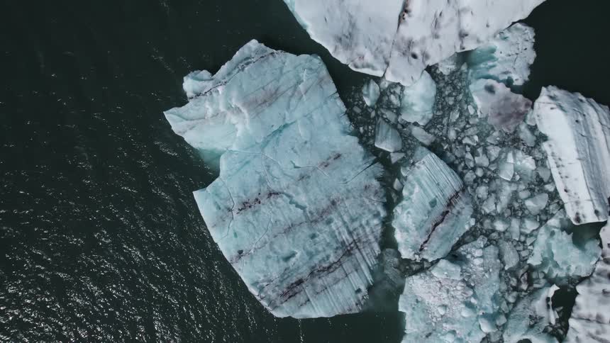Aerial view of icebergs and broken ice pieces in the water