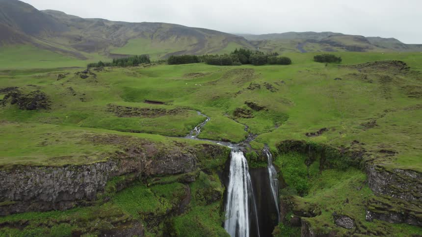 Several small creeks meet at the edge of a canyon where a waterfall rushes over the side