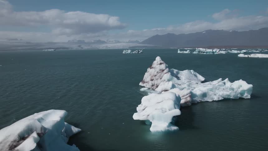 Large glaciers in the ocean with birds flying overhead