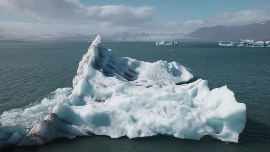 An aerial view of icebergs in ocean water in the daytime