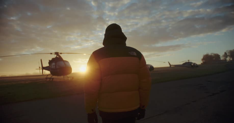 A person walking toward a helicopter