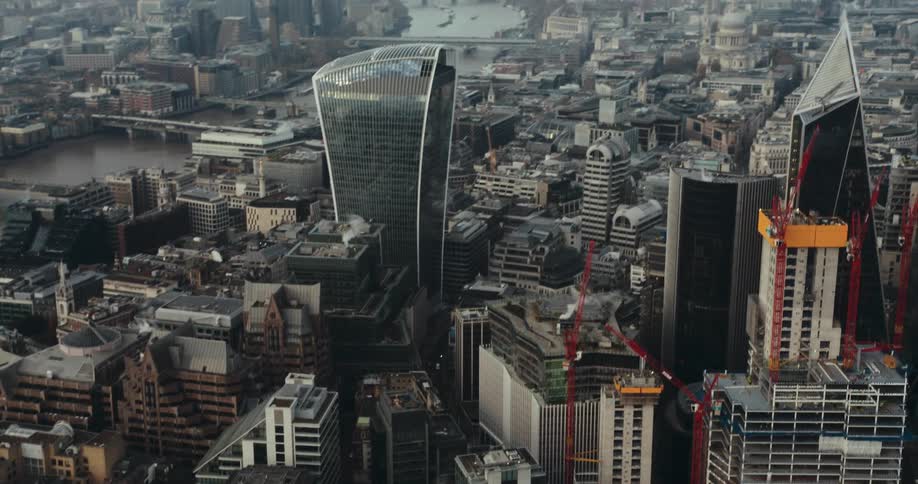 An aerial view of skyscrapers with construction cranes in a downtown area