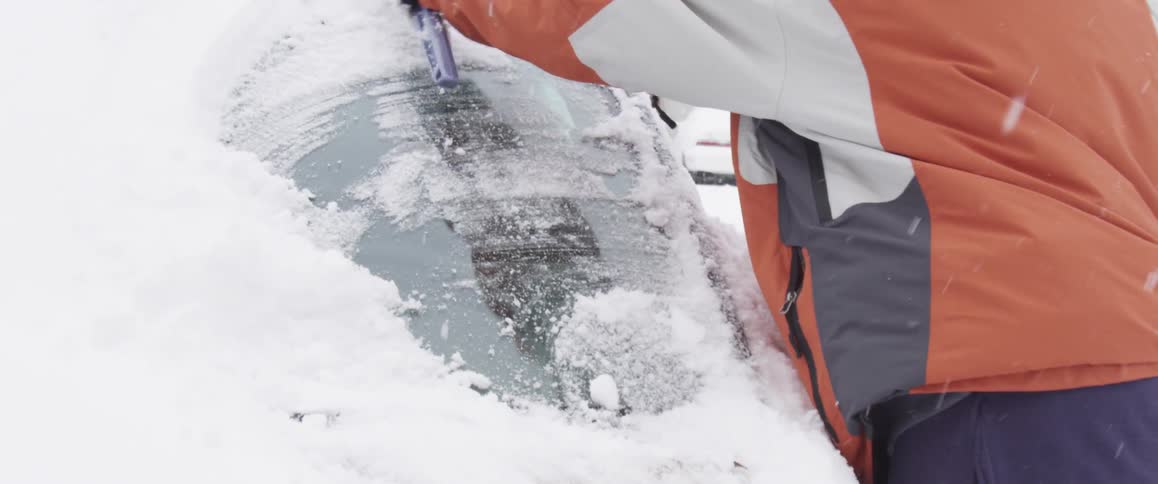 Snow being wiped from a car windshield