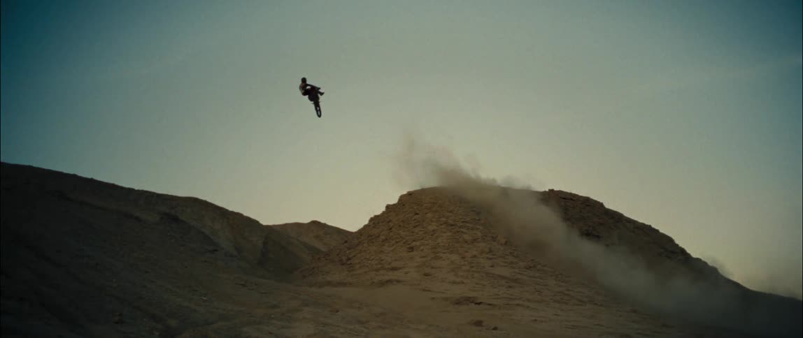 A person does a high jump on his dirt bike