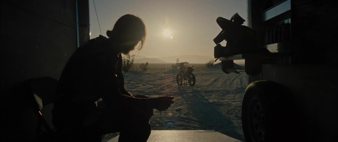 A person sitting looking out at a motorcycle