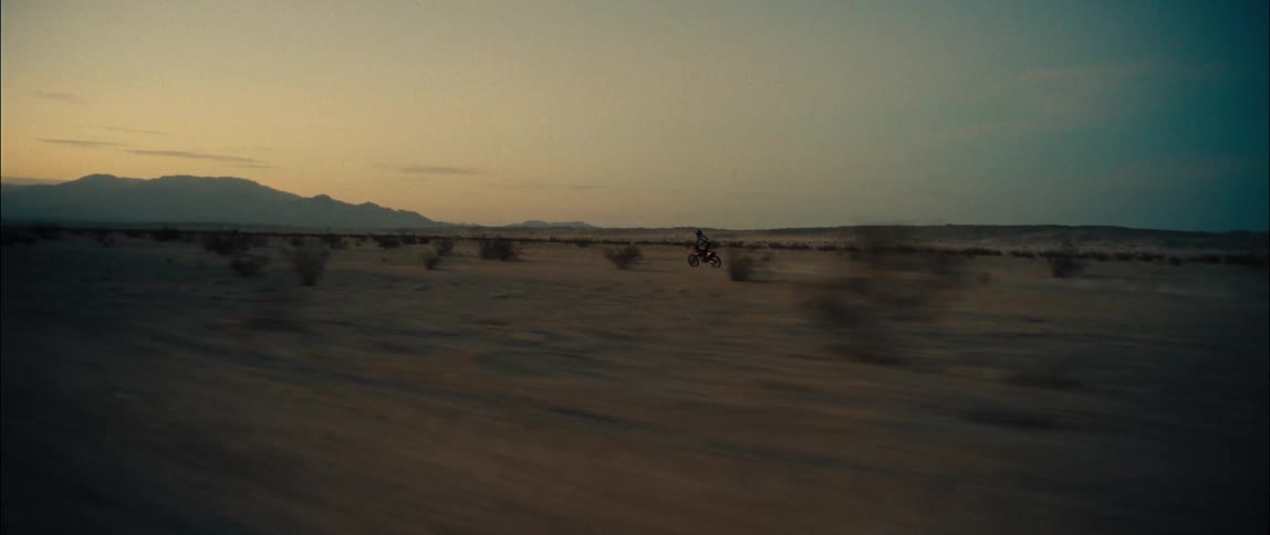 A bicyclist rides through rough desert