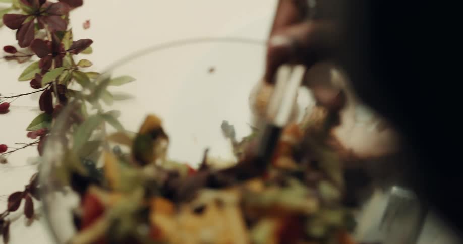 A man spoons salad onto a plate with turkey and potatoes
