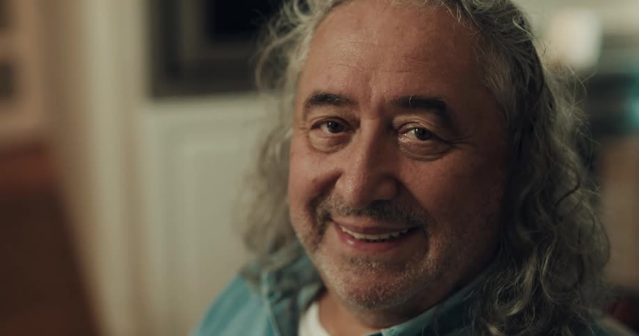 A man turns and gives a big smile