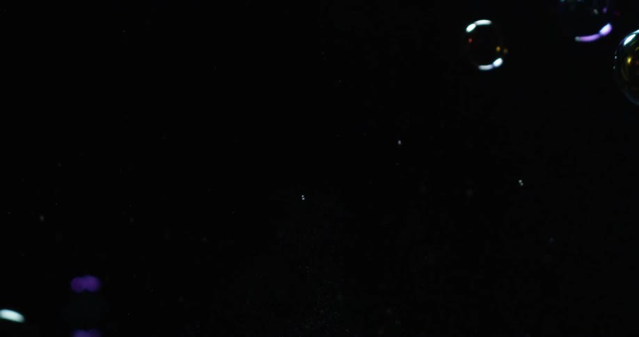 Bubbles float around in a dark area