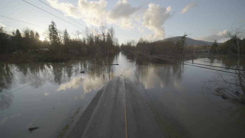 Traverse over a two lane road that becomes submerged under murky flood water