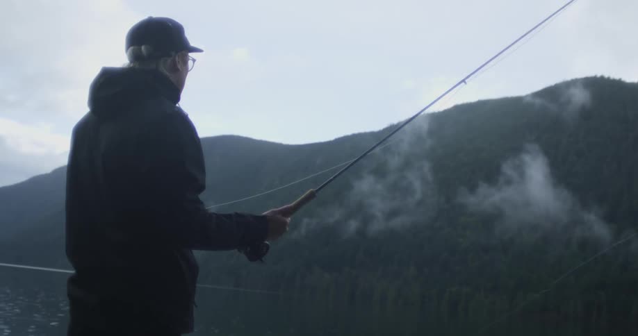 A man casts a fishing line into a lake