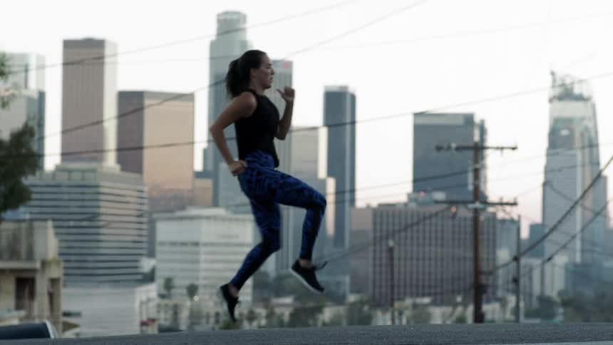 A woman jogs down a street