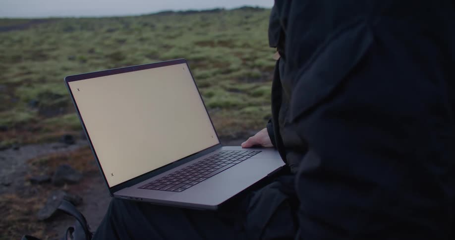 Someone is outside and has a laptop computer sitting on their legs