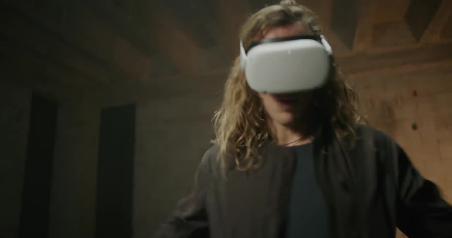 Man plays a game with a virtual reality headset and controllers