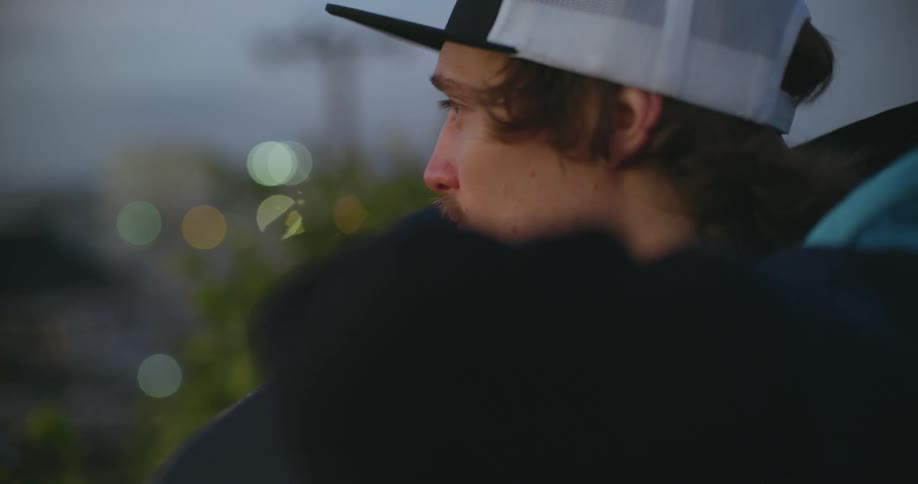 Man wearing a baseball cap looks around