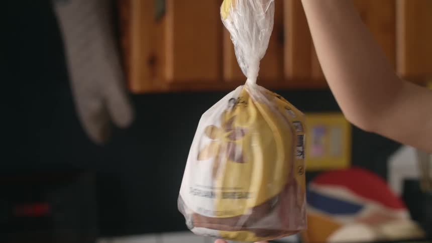 A person untwist a plastic bag of white bread on the kitchen at home