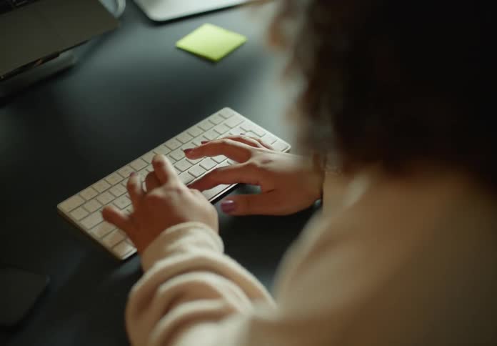 A woman is typing on a keyboard