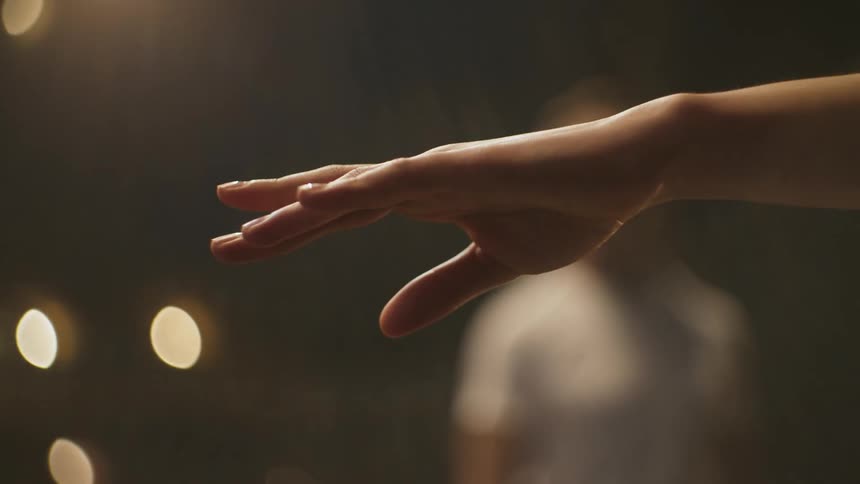 Male walks in parallel to ballerina as she reaches her hand out