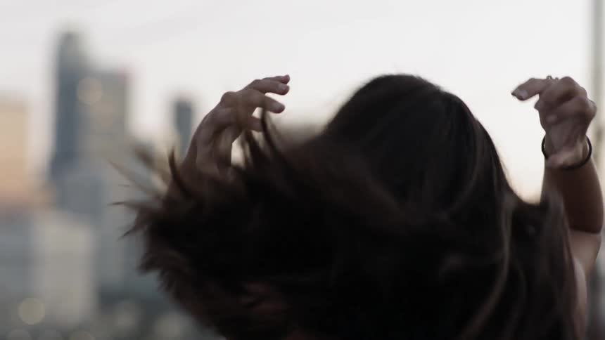 A woman pulls her hair behind her head
