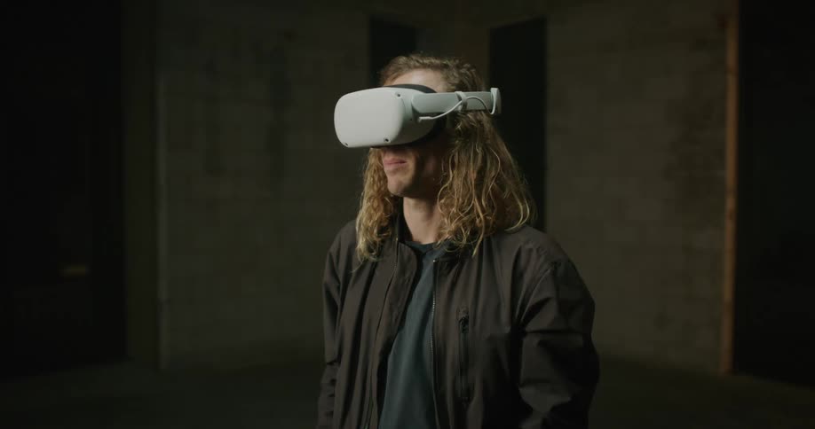 A man is standing inside a building wearing a virtual reality headset