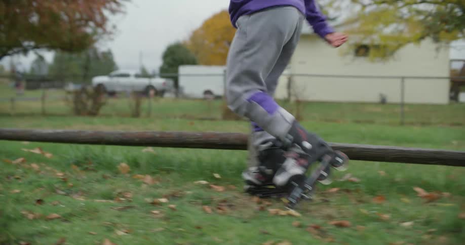 Young child learning how to rollerblade in the neighborhood