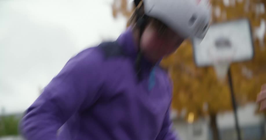 Adult helps teenage girl learn to use inline skates