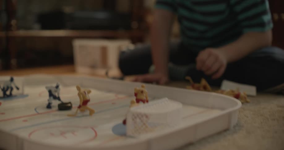 A girl with downs syndrome playing a hockey game on a rug