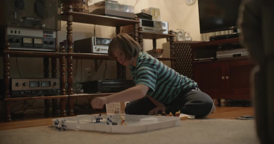 A girl is playing with some toys in a game as she sits on the floor