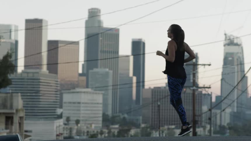 A woman in patterned pants jogging in a small circle