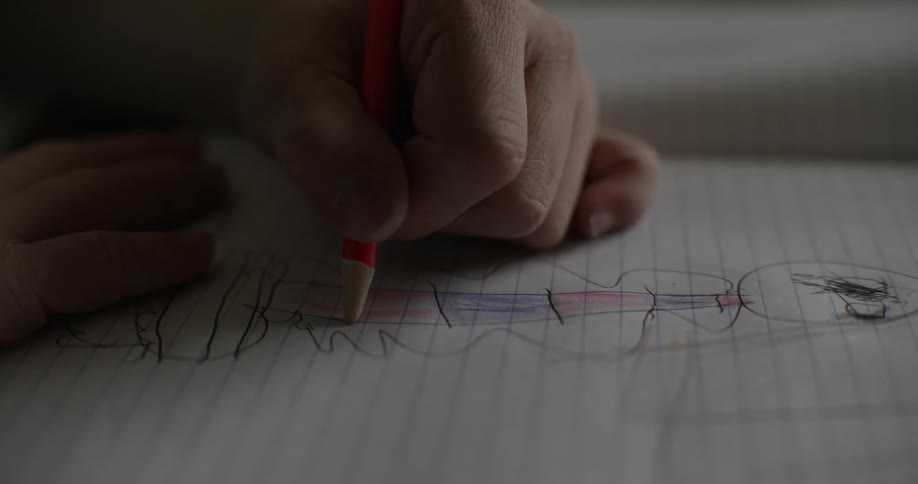 A child is drawing a picture on a piece of paper