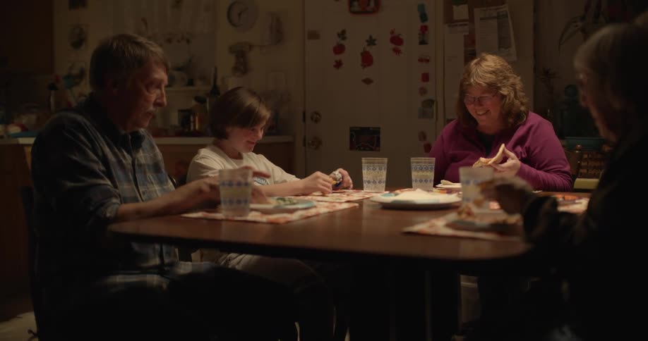 Family of four sitting on the dinning table at home eating dinner
